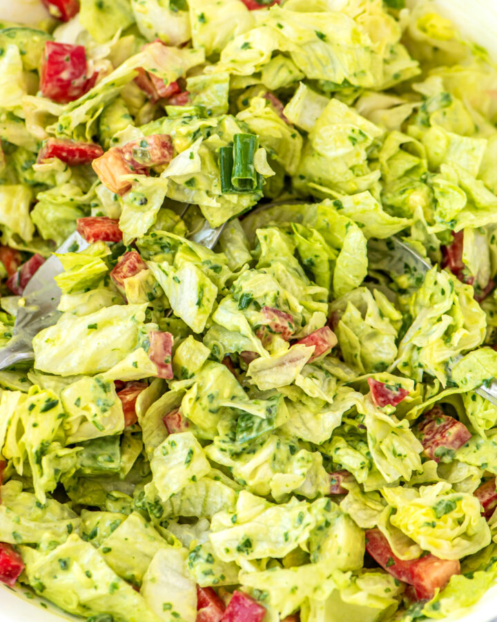 Homemade salad dressing mixed into a salad with vegetables.