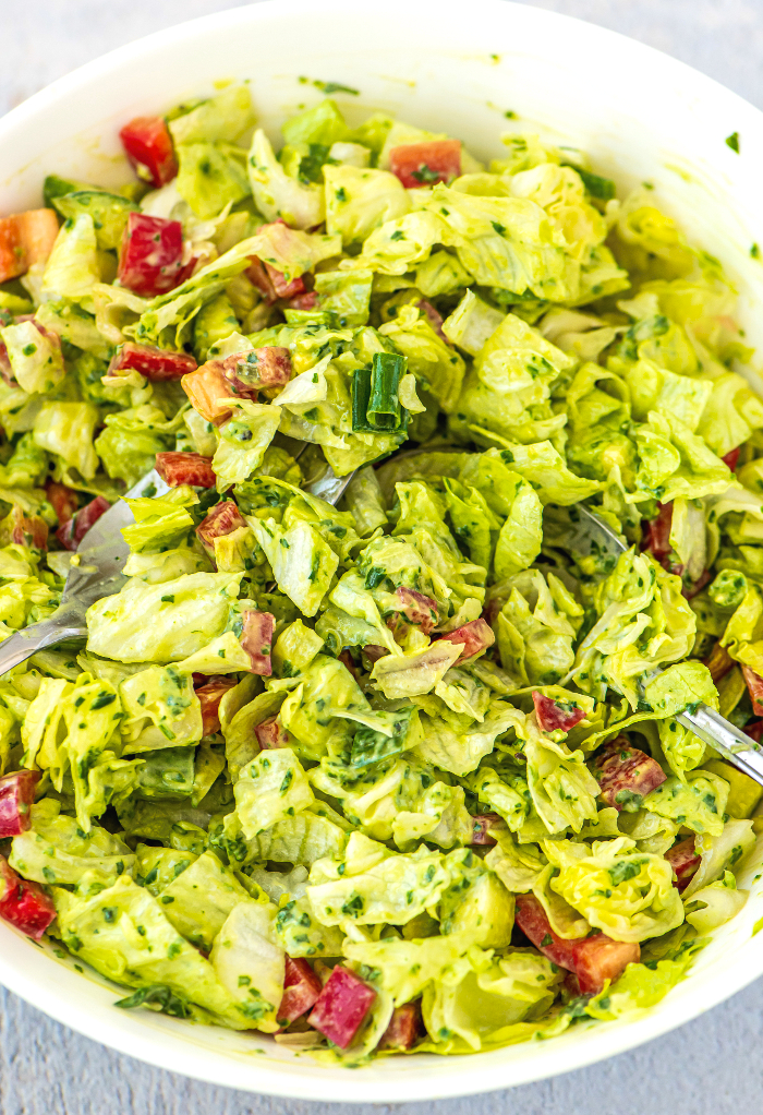 Green goddess salad in a white serving bowl ready to eat. 