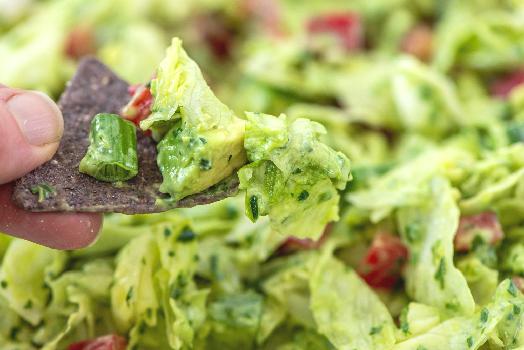 Salad with a blue tortilla chip to eat like a dip.