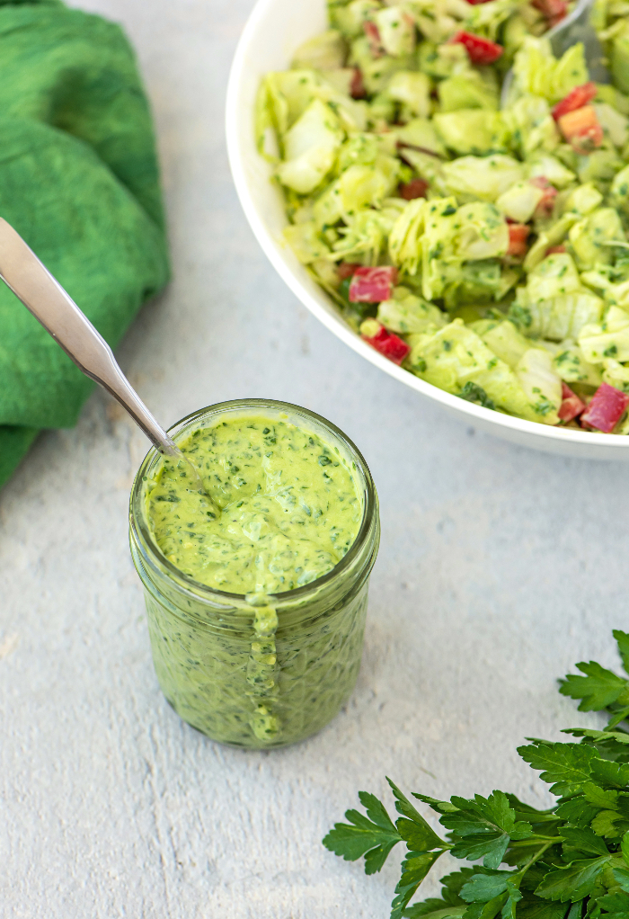 Homemade green goddess salad dressing topped on salad. 