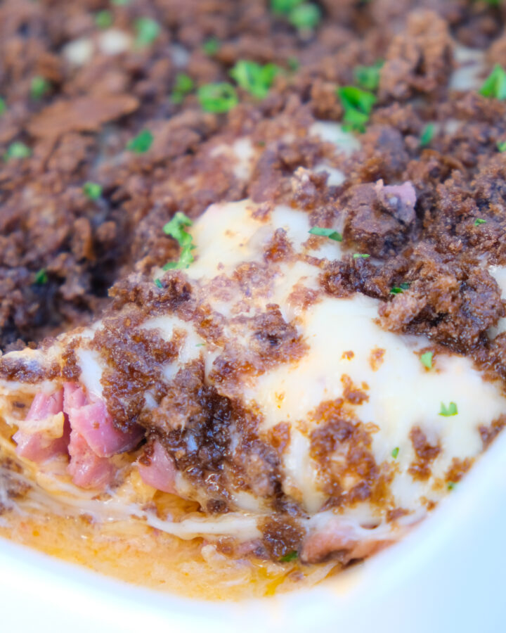 Reuben Casserole in a white dish scooped up ready to serve.