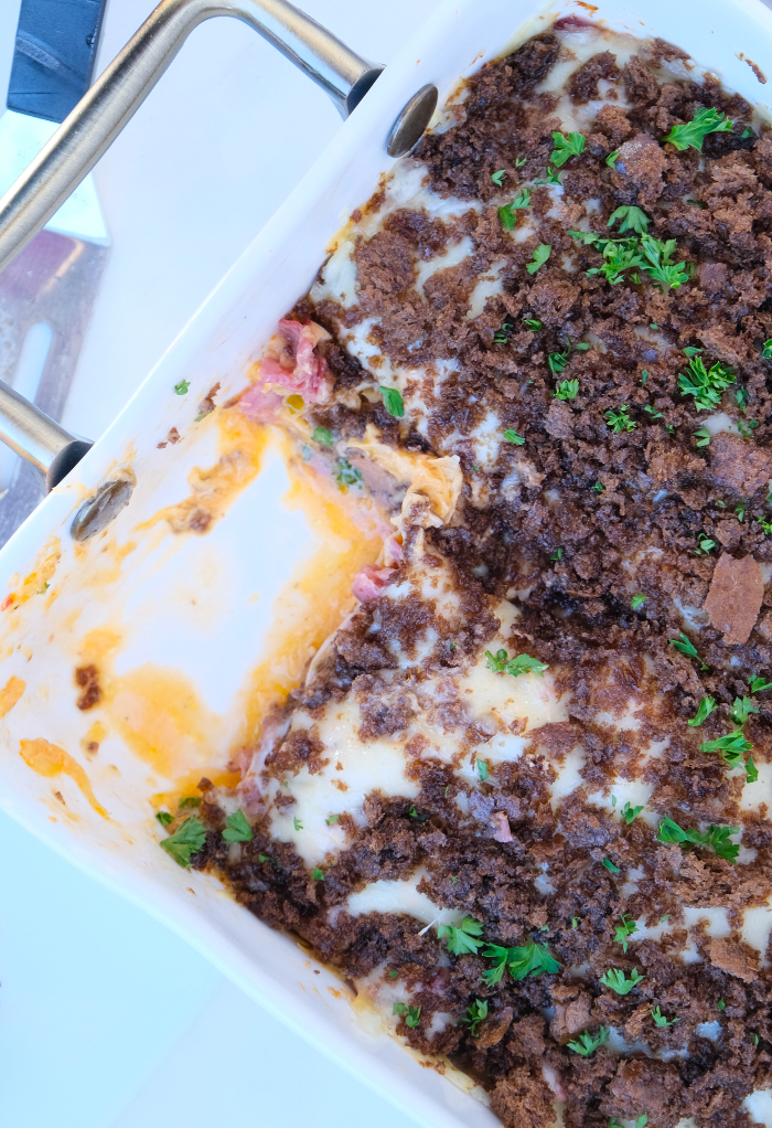 Reuben casserole with a slice removed from a white casserole dish. 