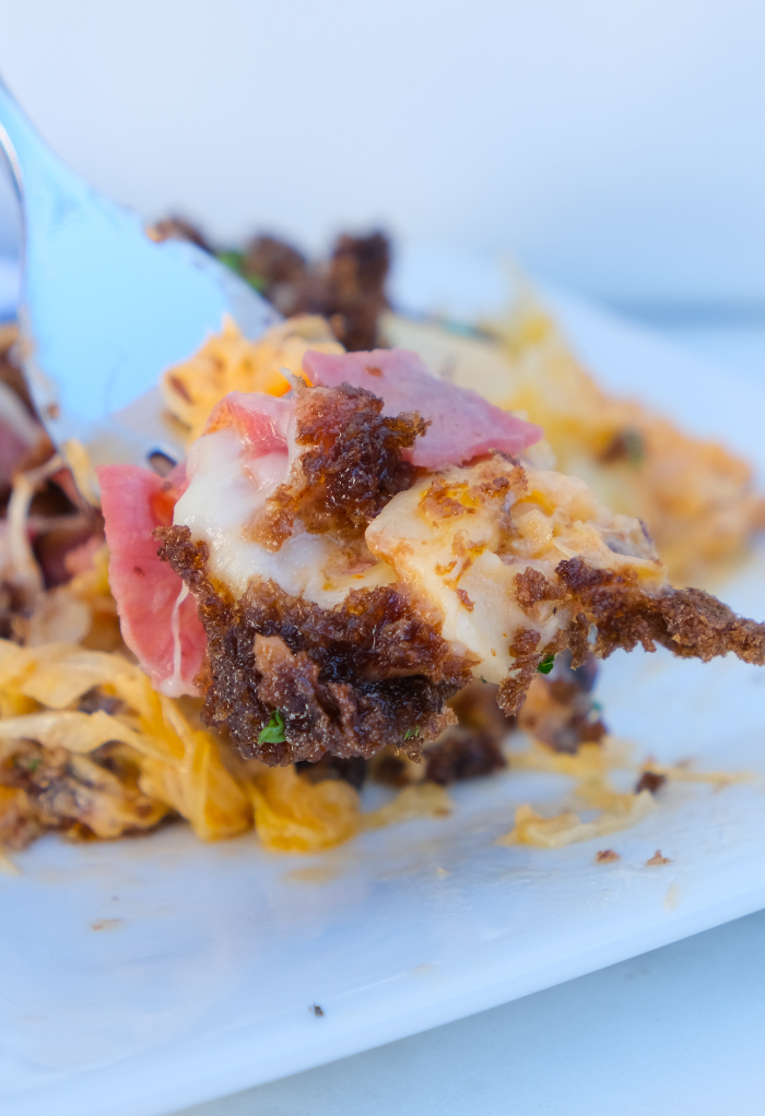 Fork full of Reuben casserole over a white plate.