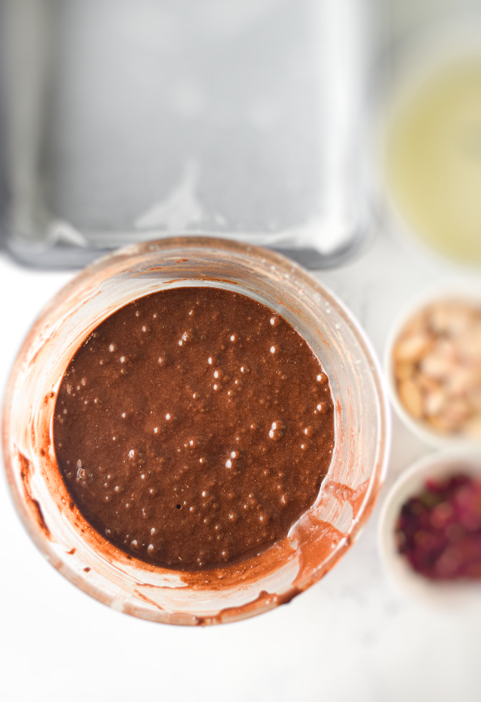 Dry and wet ingredients in a mixing bowl to make brownies. 