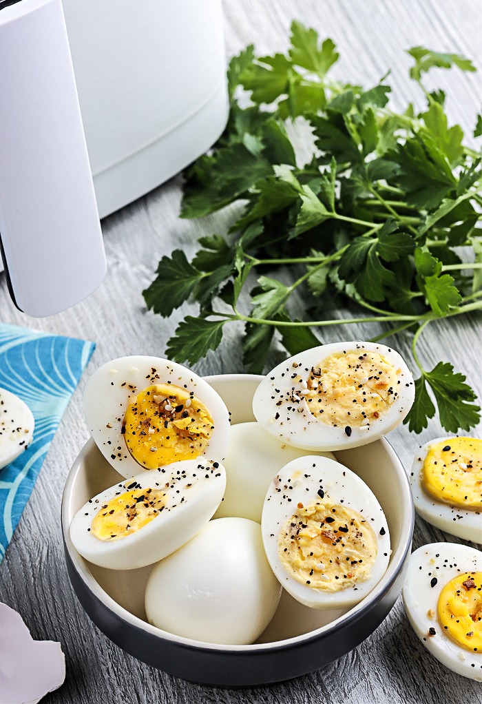 Hard boiled eggs in a black bowl cooked in an air fryer.