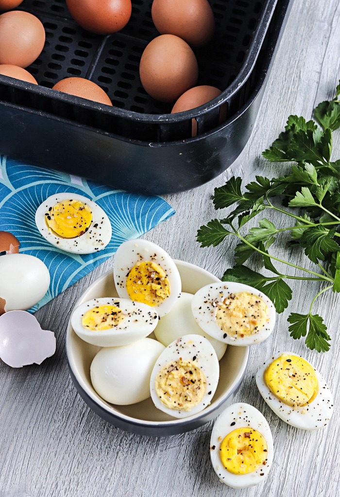 Top view of hard boiled eggs sliced in half with pepper and salt in a small serving bowl. 