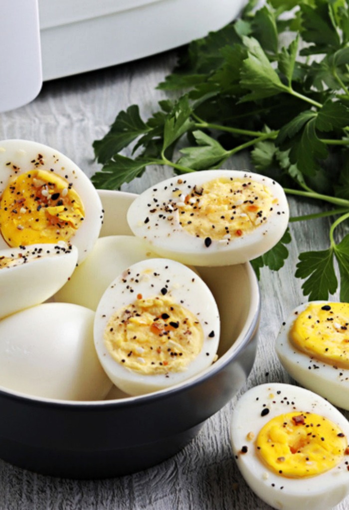 Fresh cooked hard boiled eggs sliced and seasoned with pepper. 