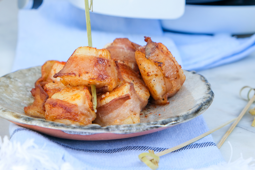 Air fryer scallops wrapped in bacon on a serving dish ready to enjoy. 