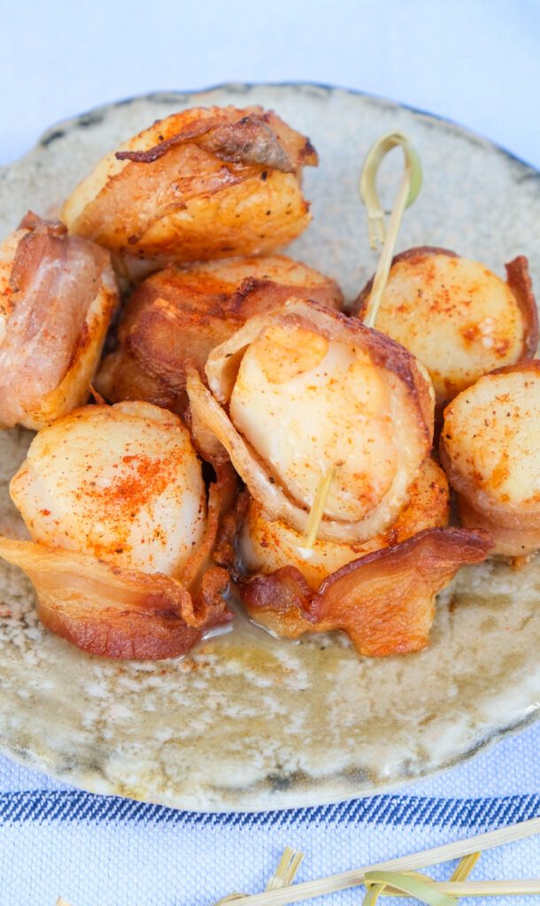 Top view of scallops wrapped in bacon on a serving dish ready to eat. 
