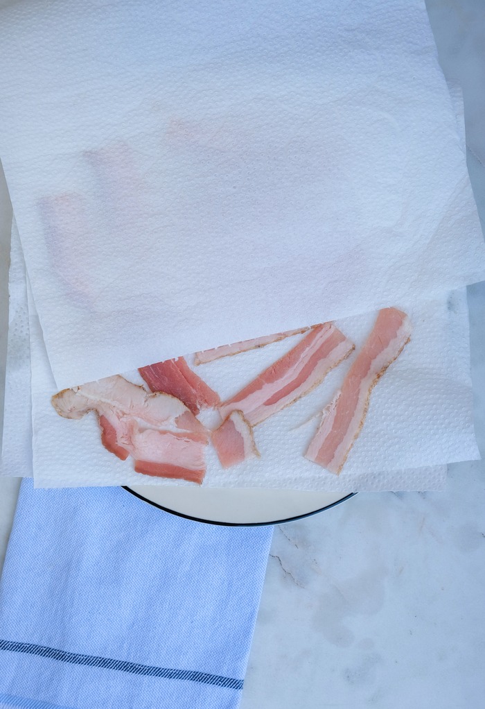 Sliced bacon on a plate with paper towels. 