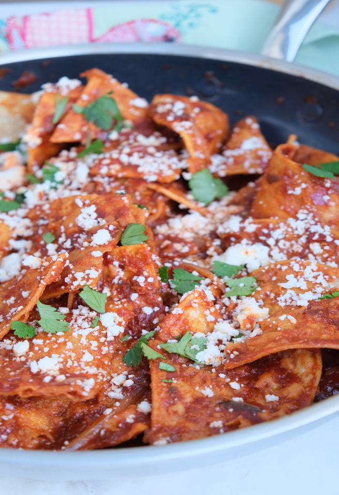 Chilaquiles in a skillet topped with cheese and cilantro. 