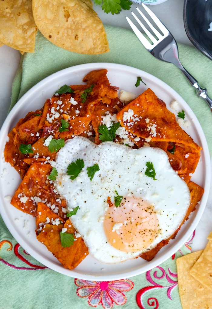 Top view of chilaquiles topped with an egg. 