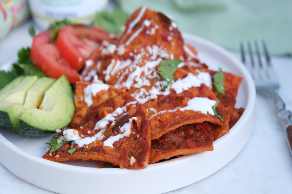 Homemade chilaquiles recipe topped with cheese and creama. 