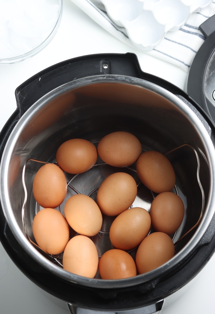 Adding eggs to an Instant Pot before pressure cooking. 