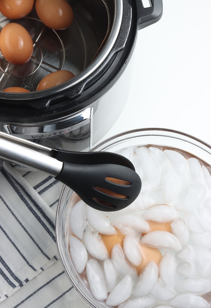 Clear bowl filled with ice cooling down fresh cooked hard boiled eggs. 