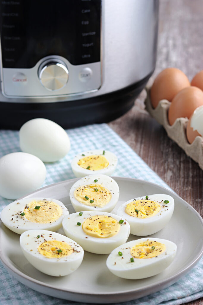 Hard boiled eggs on a gray plate sliced in half ready to eat. 