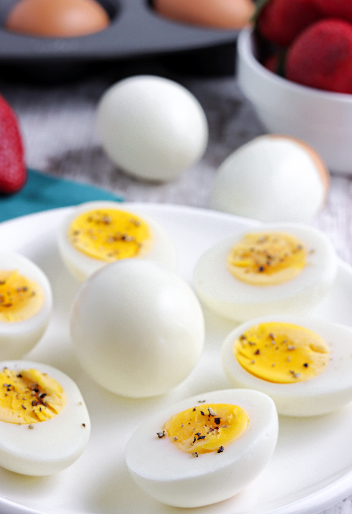 Cooked eggs on a white plate sliced in half ready to eat. 