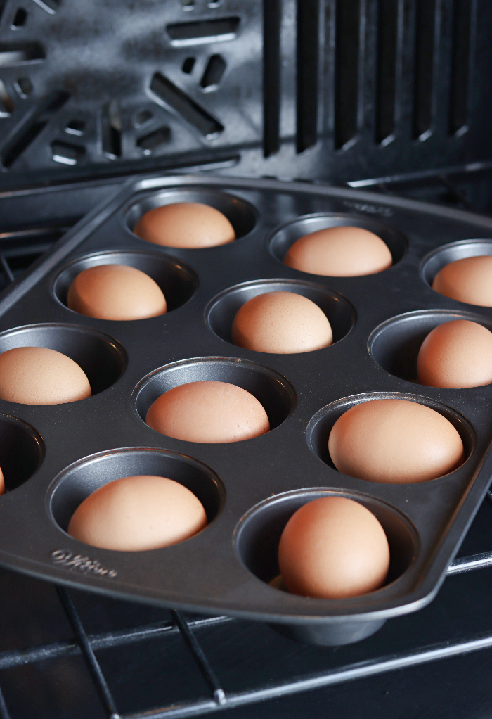 Eggs placed in a muffin tin ready to cook in the oven. 