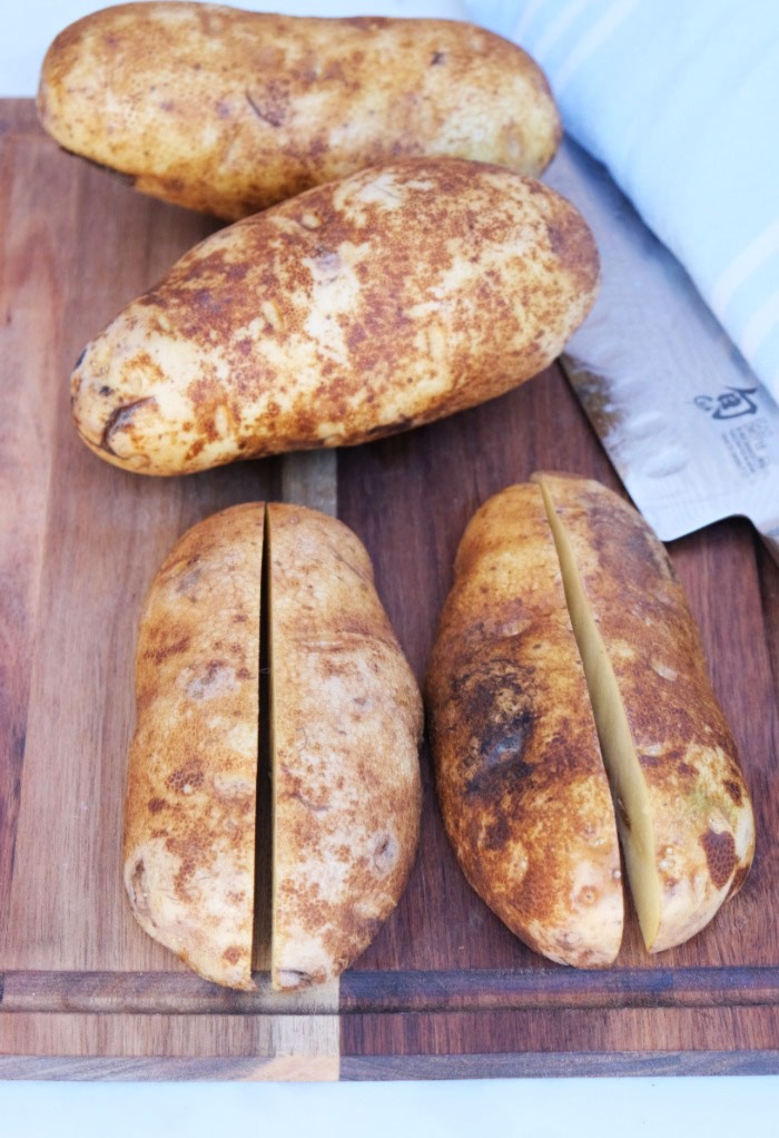 Flat size of cut potatoes on a cutting board ready to cut into wedges. 