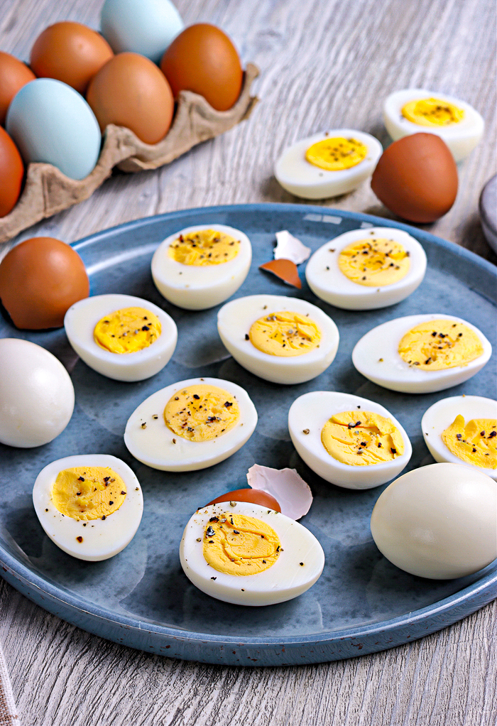 Hard cooked brown eggs in the back of sliced eggs on a plate. 