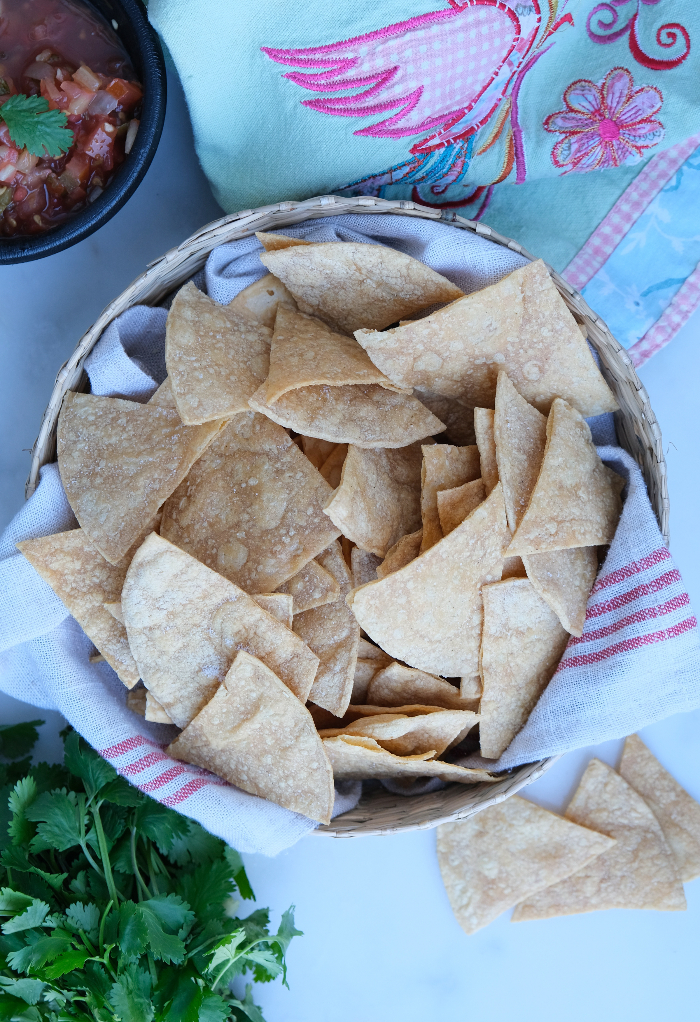 Top view of fresh homemade tortilla chips in a basket ready to eat.