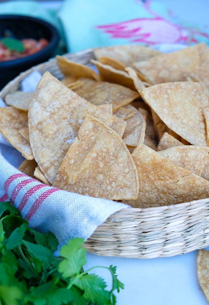 Homemade baked tortilla chips in a basket ready to eat.