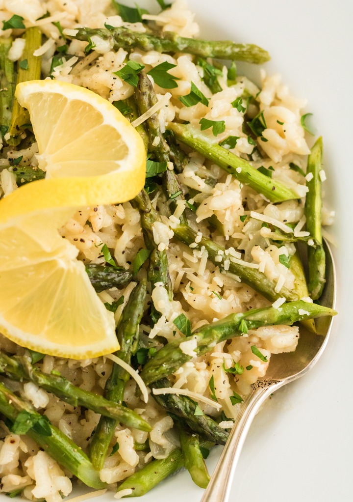 Close view of asparagus with risotto topped with lemon. 