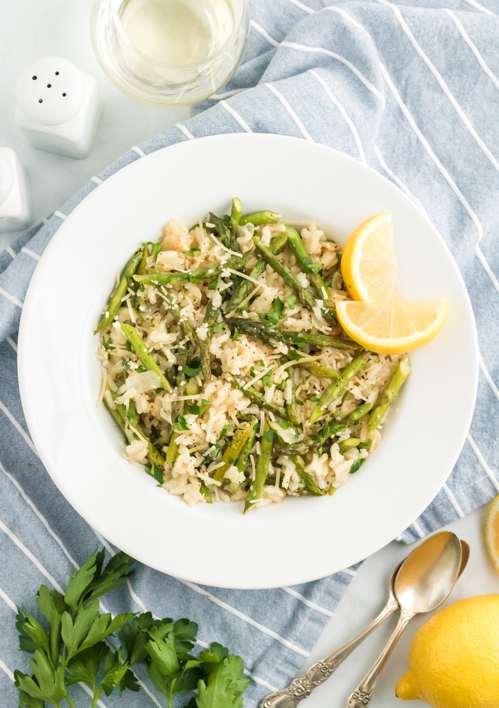 Top view of risotto dish with lemon in a white bowl. 