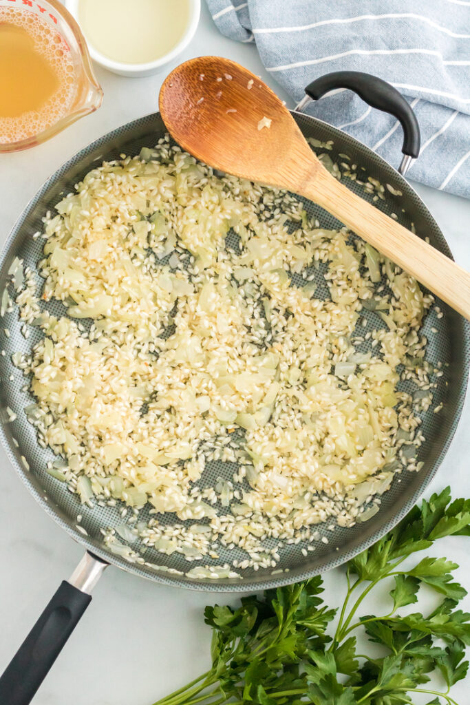 Adding risotto to sautéd onion and spices. 