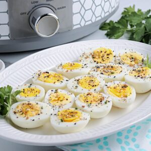 Hard boiled eggs on a white serving dish ready to eat.