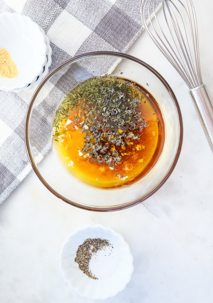 Ingredients to make Greek salad dressing in a clear mixing bowl. 