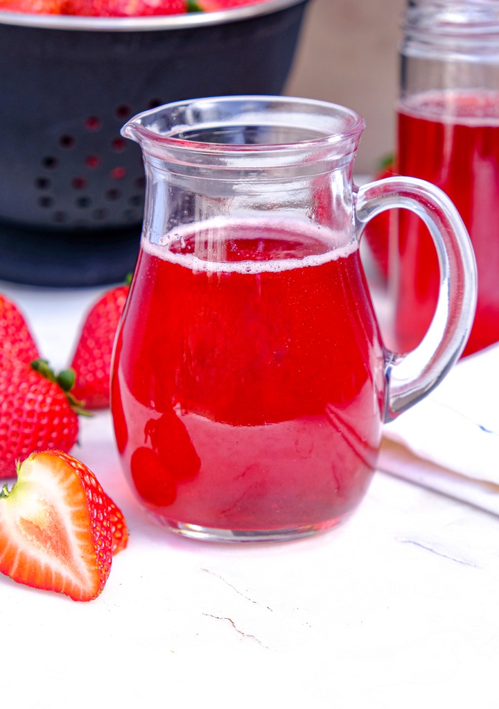 Homemade fruit flavored syrup in a small pitcher.