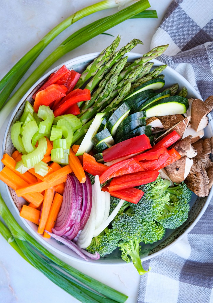 A variety of fresh vegetables in a mixing bowl. 