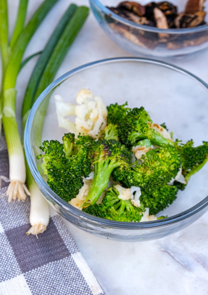 Broccoli and mushrooms in two small glass bowls. 