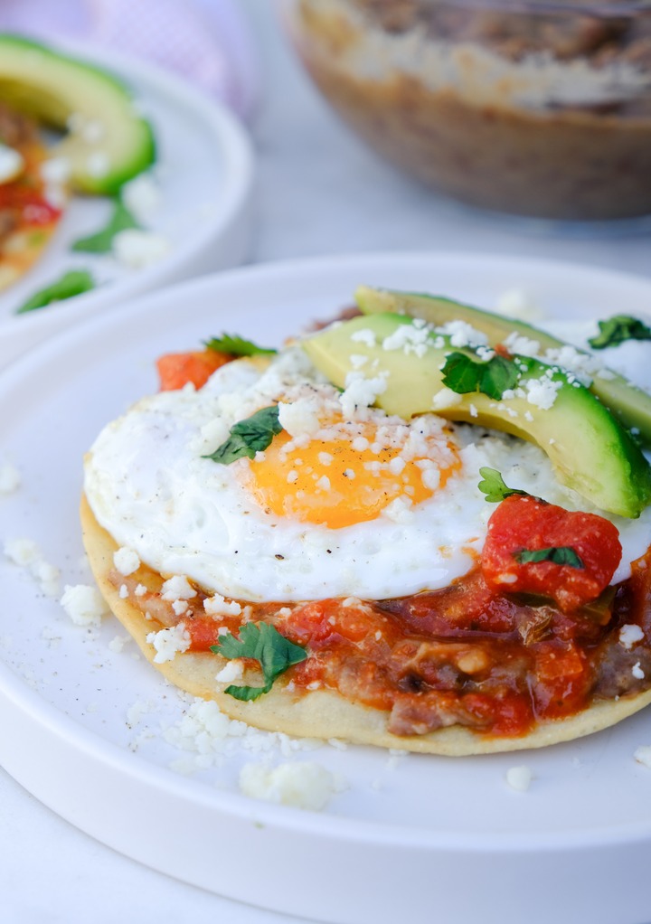 Homemade huevos rancheros with avocado slices on the side. 