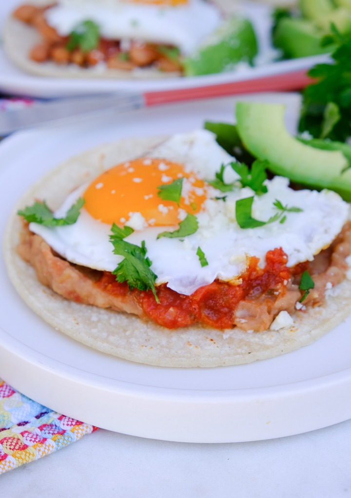 Huevos rancheros on a white plate ready to eat. 