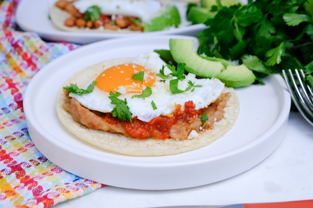 Huevos rancheros on a white plate ready to eat. 