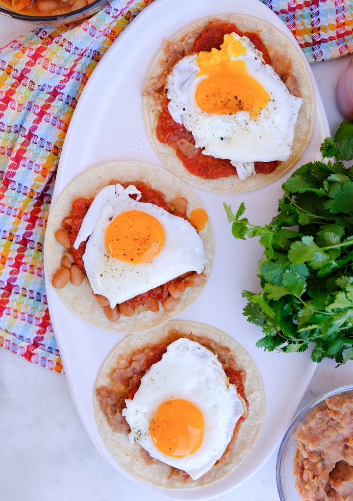 Sunny side up eggs on top of ranchero sauce and beans.