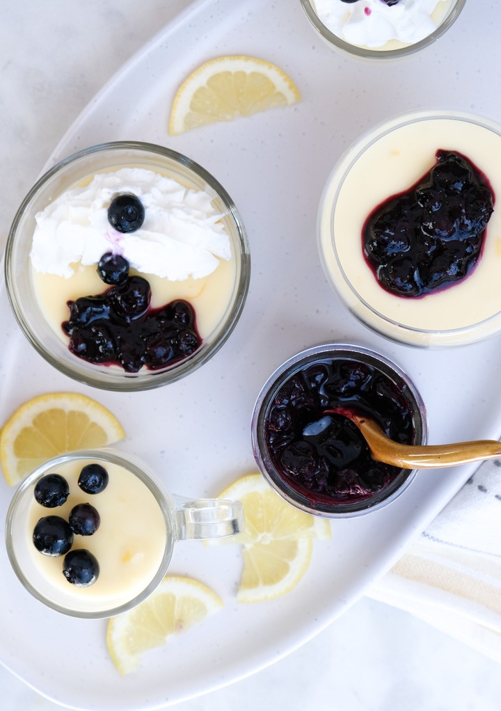 Top view of lemon posset topped with blueberry sauce and whipped cream. 