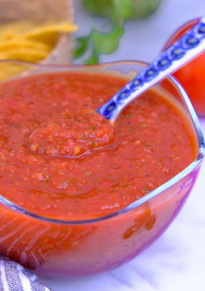 Blended ranchero sauce in a clear bowl with a spoon in it ready to serve. 