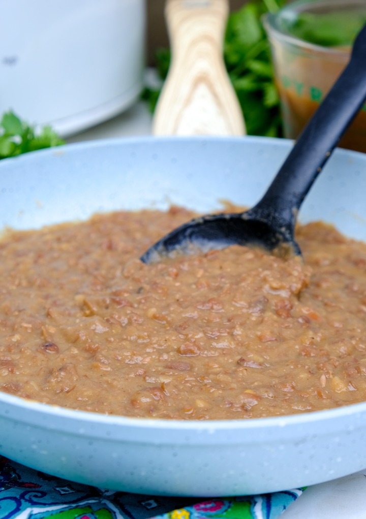 Mashed beans in a a blue skillet. 