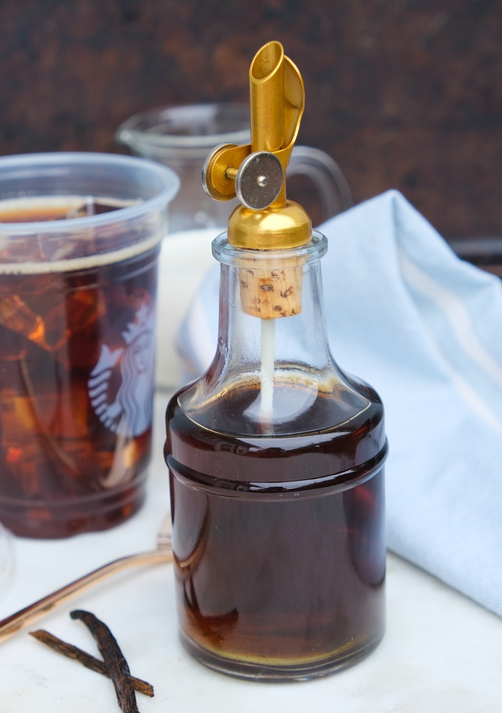 Homemade vanilla syrup in a glass jar with a pour top.