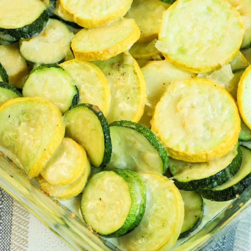 Zucchini and squash roasted in a clear baking dish.