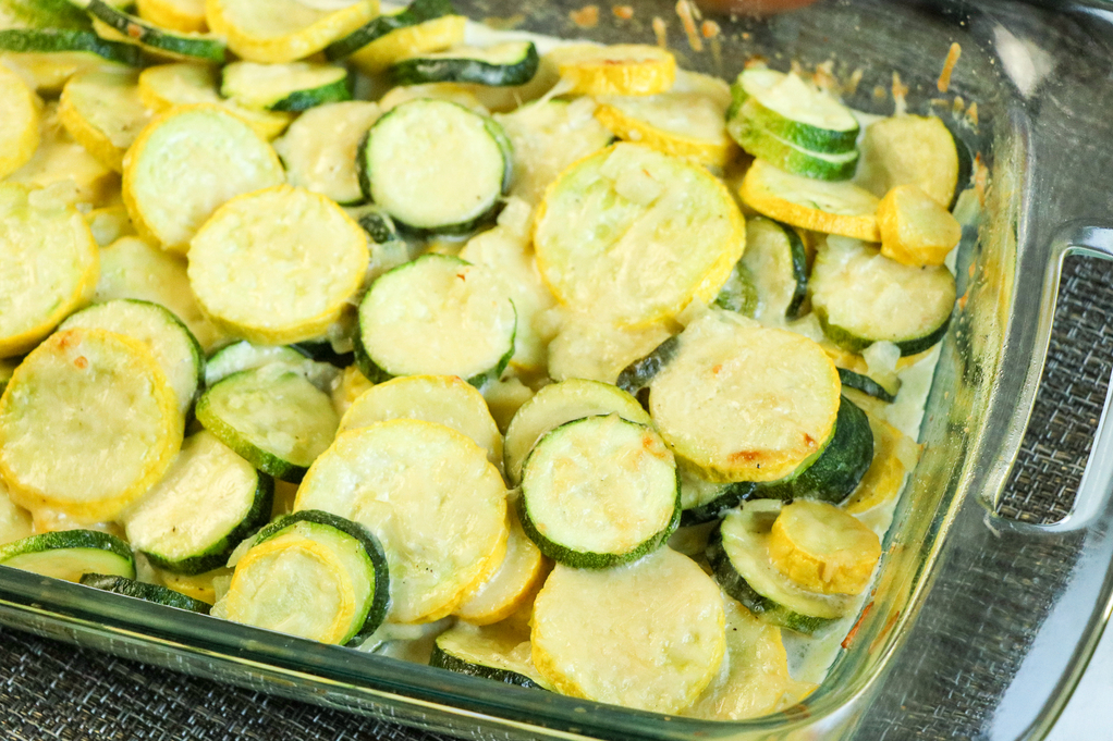 Vegetable casserole in a clear glass baking dish. 