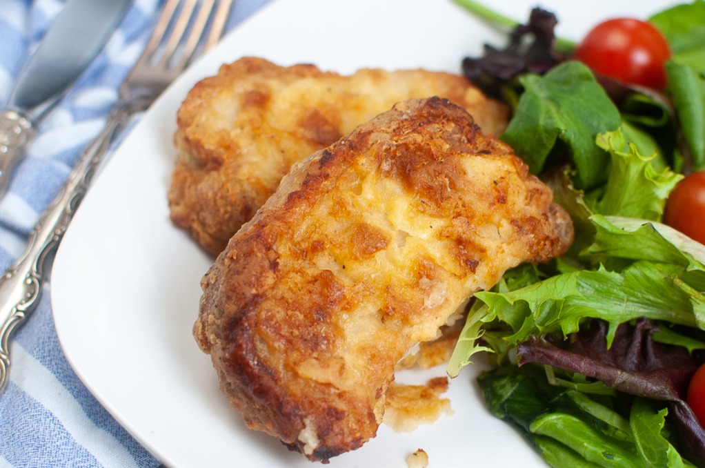 Instant pot air fryer pork chops with a green salad on a white plate. 