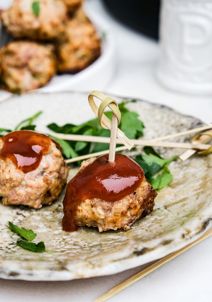 Turkey meatballs on an brown appetizer plate with a spear in the top.  