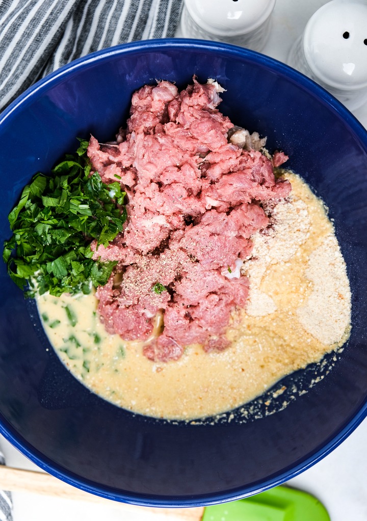 Turkey meatball mixture in a blue mixing bowl. 