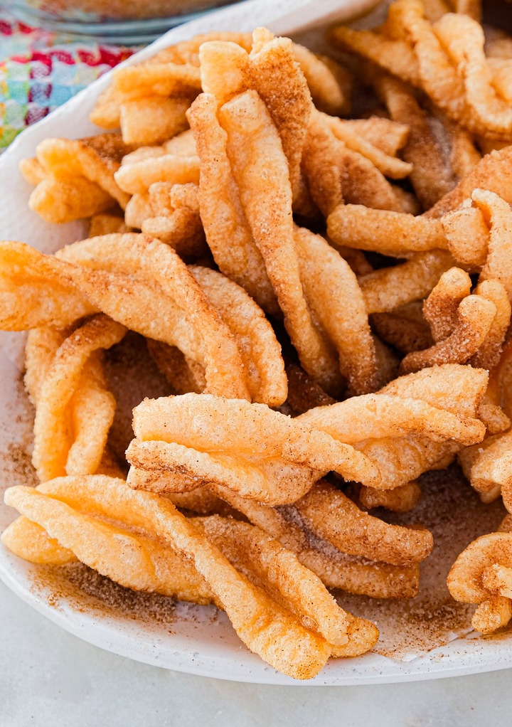 Homemade cinnamon twists on a white serving plate. 