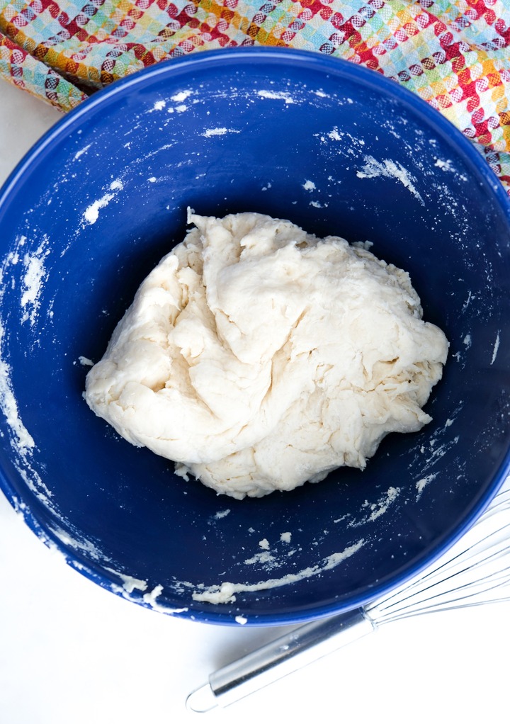 Homemade tortilla dough recipe without lard in a blue mixing bowl. 