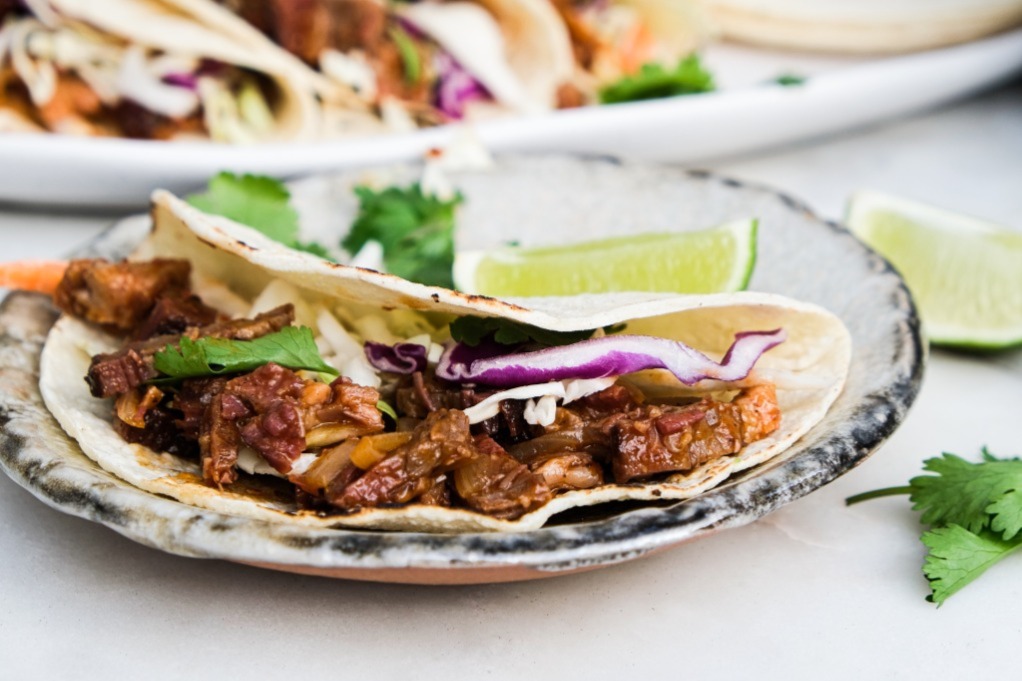 Tacos with leftover beef brisket on a small plate.